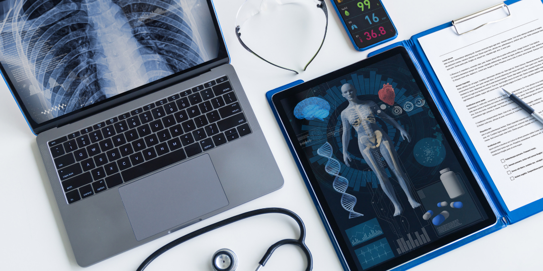 laptop with a chest-ray next to an digital tablet with a body scan image and a pad with handwritten medical notes, plus a stethoscope on the desk.