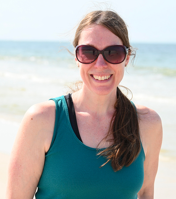 MSAI student Tammy Dugan standing on a beach smiling at the camera with sunglasses on.